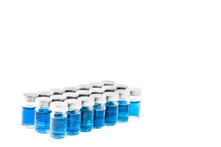 Small bottles with blue chemicals isolated on a white backgroundの写真素材
