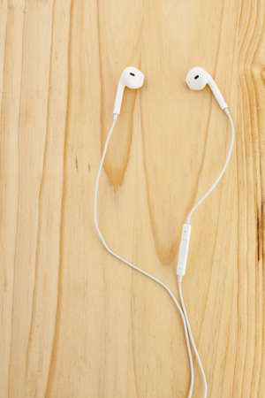 Earpods on a wooden surfaceの写真素材