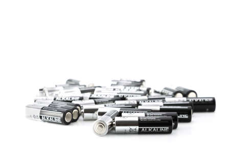 Silver and black batteries scattered and isolated on a white backgroundの写真素材