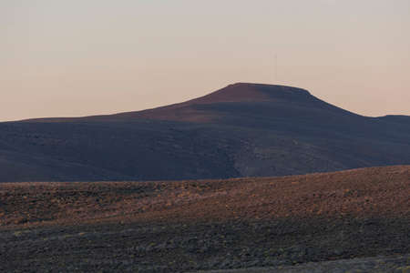 A landscape with fields and mountains against clear sky backgroundの写真素材