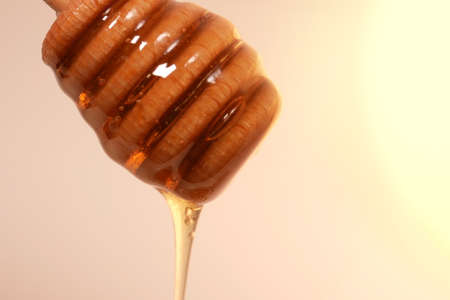 Honey drizzling from wooden honey dipper