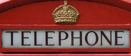 Sign and crown on red British telephone box. Close up.のeditorial素材