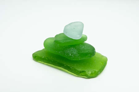 Green glass pieces found on beach. Sea glass worn smooth by the ocean. Isolated on white background.の写真素材