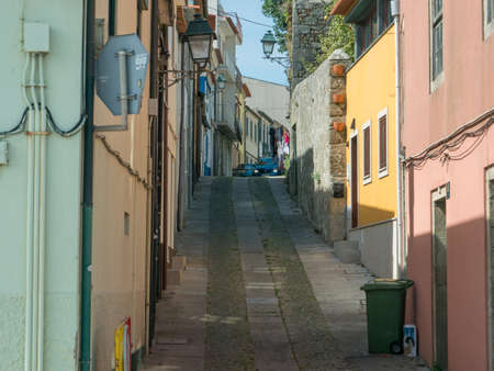 Small narrow street with traditional Portuguese architecture houses and colorful buildings in Vila do Conde, Portugal.のeditorial素材