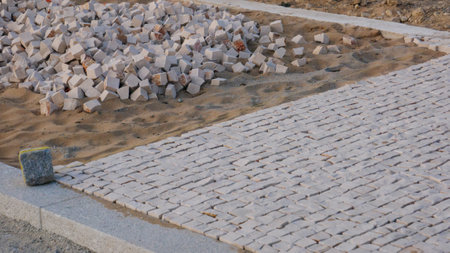 Portuguese sidewalk, pavement under construction in Portugal, with loose stones in sand, and...