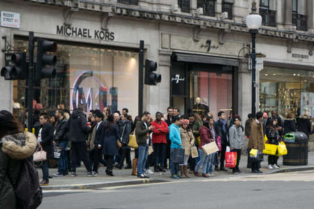 Crowds of shoppers with shopping bags on Boxing day on Regent Street, London, England.