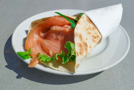 Smoked salmon wrap on a white plate. Healthy snack.の写真素材