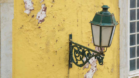 Old vintage street lamp on side of colorful yellow building in Faro, Algarve, Portugalの写真素材