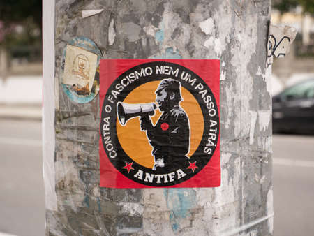 Red Antifa sticker on a lamp post in Porto city, Portugalのeditorial素材
