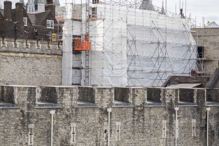 Tower of London under renovation with scaffolding and plastic sheets. London, England.