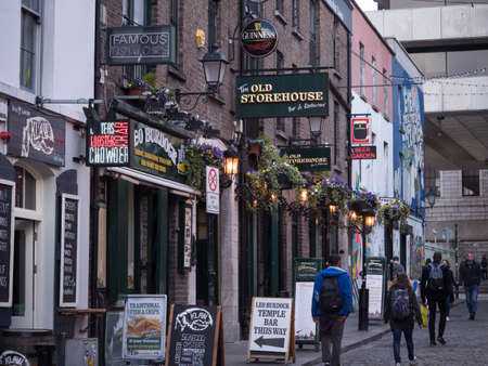 Fish and chip shop, Irish pub with Guinness sign, and tourists walking in the street in Temple Bar, Dublin, Irelandのeditorial素材
