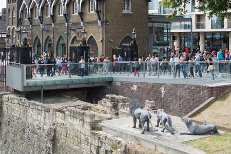 Lion statues at the Tower of London with tourists walking in the backgroundのeditorial素材