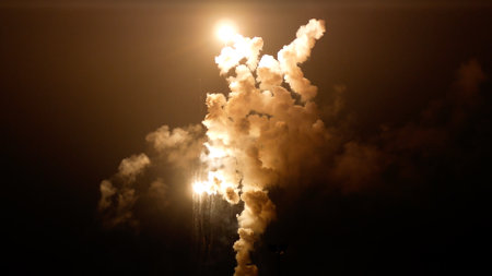 Explosion lights up the night sky with smoke column