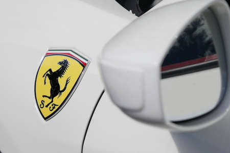 Wing mirror and Ferrari badge on white Ferrari luxury car