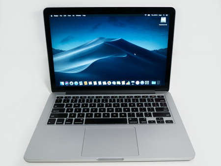 Apple MacBook Pro 13 inch retina laptop on white desk running macOS