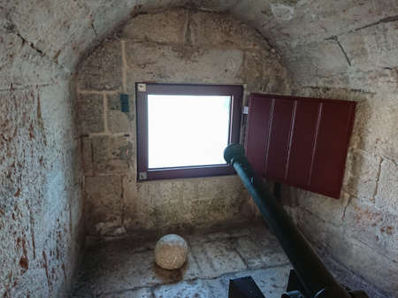 Ancient cannon inside Belem Tower pointed through an embrasure in the fort wall.のeditorial素材