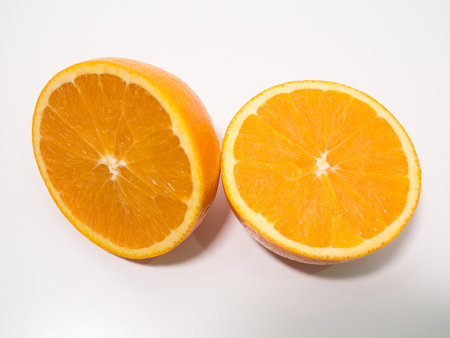 Sliced fresh orange cut in half on white background, overhead viewの写真素材