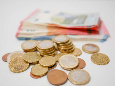 Euro coins and banknotes on a white desk. Close upの写真素材