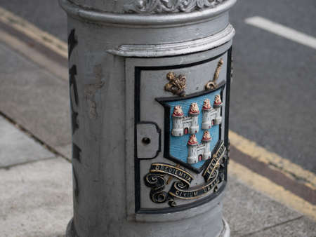 Old Street lamp in Dublin, Ireland. Close up of coat of arms in colour with Latin motto Obedientia Civium Urbis Felicitasのeditorial素材
