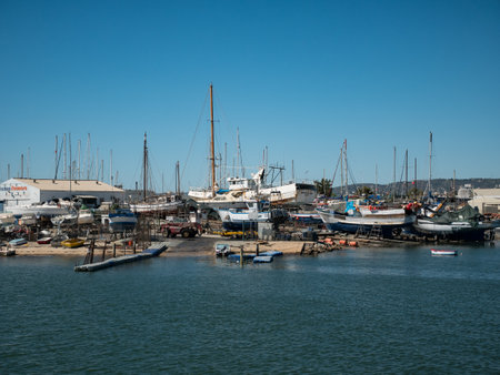 Boatyard in Algarve, Portugal with many boats under repair on a sunny summer day with blue sky.のeditorial素材