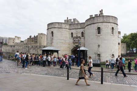 Main entrance to Tower of London in England with tourists waiting in line.