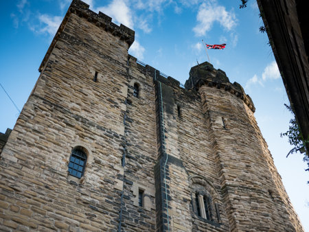 Newcastle Castle keep in New castle upon Tyne, England, from below with British Union Jack flag...