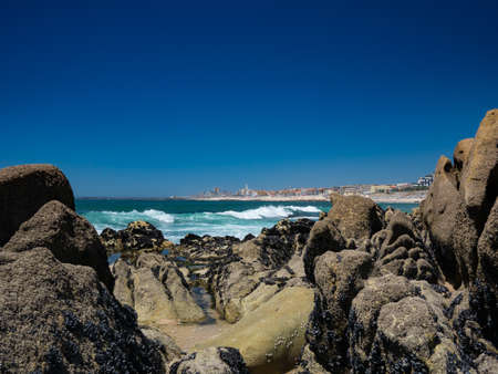 Povoa de Varzim, Portugal viewed from beach with rocks and ocean in foregroundの写真素材