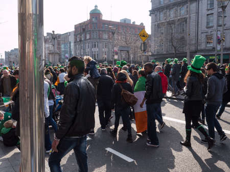 Crowds of diverse people in green hats celebrate St. Patrick's day in Dublin, Ireland.のeditorial素材