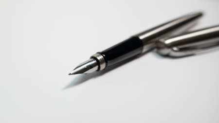 Fountain pen on a sheet of white paper. Close up, shallow depth of field.
