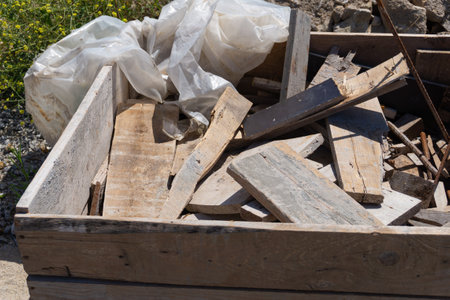 Wood scraps, left in a box on construction site with steel bars for concrete reinforcement.の写真素材