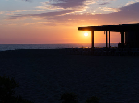 Restaurant on beach at sunset in silhouette in Portugal.の写真素材