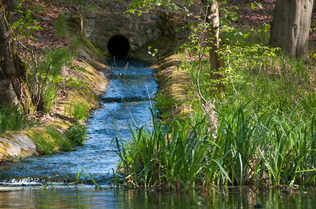 Water flowing from channel to the riverの写真素材