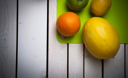 Oranges, lemons and melon on white woodの写真素材