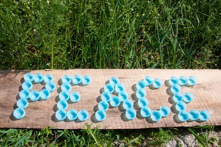 Peace composed with plastic caps on wooden boardの写真素材