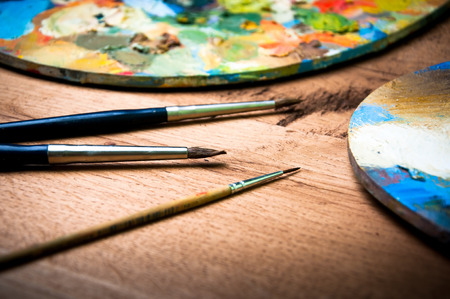 Artist paint brushes and palette on wooden backgroundの写真素材