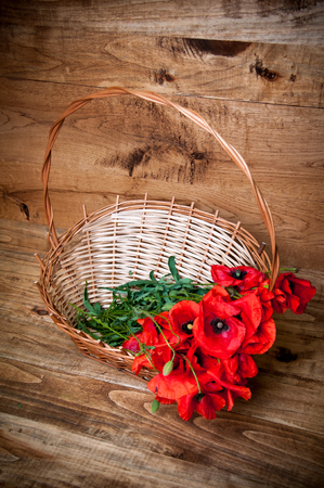 Poppies in basket on wooden backgroundの写真素材