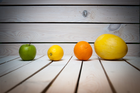 Fruits in line on white wooden tableの写真素材