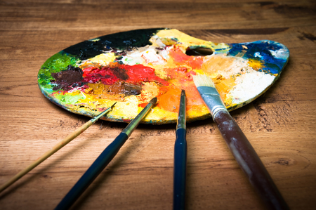 Artist paint brushes and palette on wooden backgroundの写真素材