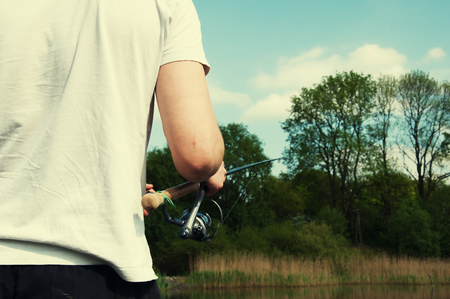 Young man fishing in the riverの写真素材
