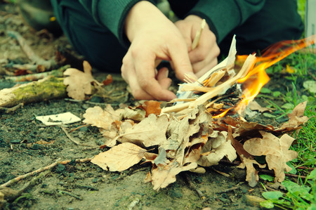 Man lighting a fire in forest