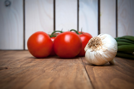 Tomatoes and garlic on wooden tableの写真素材