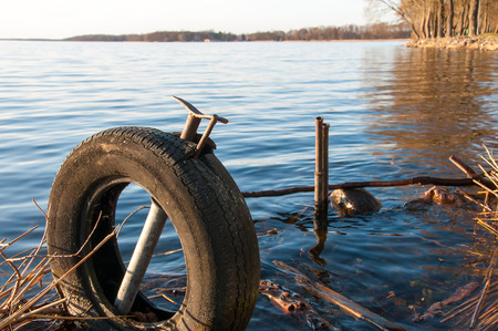 Garbage and old tire in the waterの写真素材