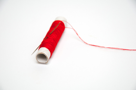 Red sewing thread and needle isolated on white backgroundの写真素材