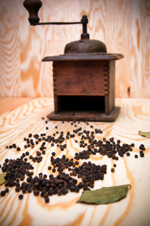 Vintage pepper mill and dried spices on wooden backgroundの写真素材