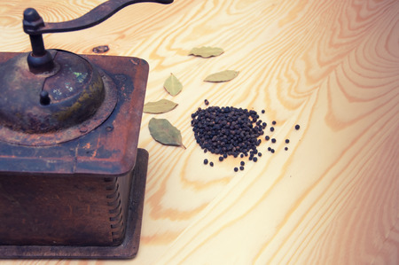 Vintage pepper mill and dried spices on wooden backgroundの写真素材