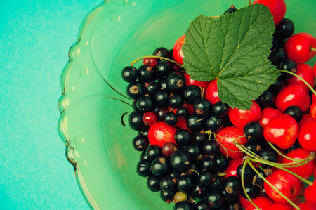 Black currant and cherries on blue backgroundの写真素材