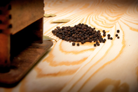 Vintage pepper mill and dried spices on wooden backgroundの写真素材