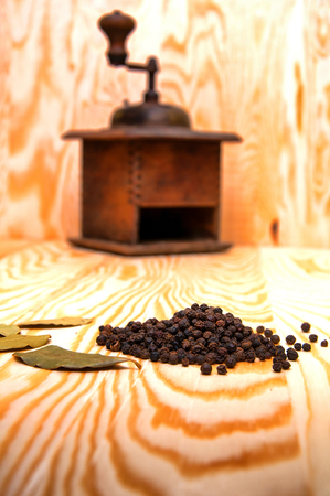 Vintage pepper mill and dried spices on wooden backgroundの写真素材