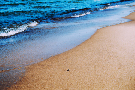 Wave of blue ocean on sandy beachの写真素材