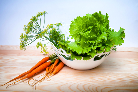 Carrots, salad and fennel on wooden tableの写真素材